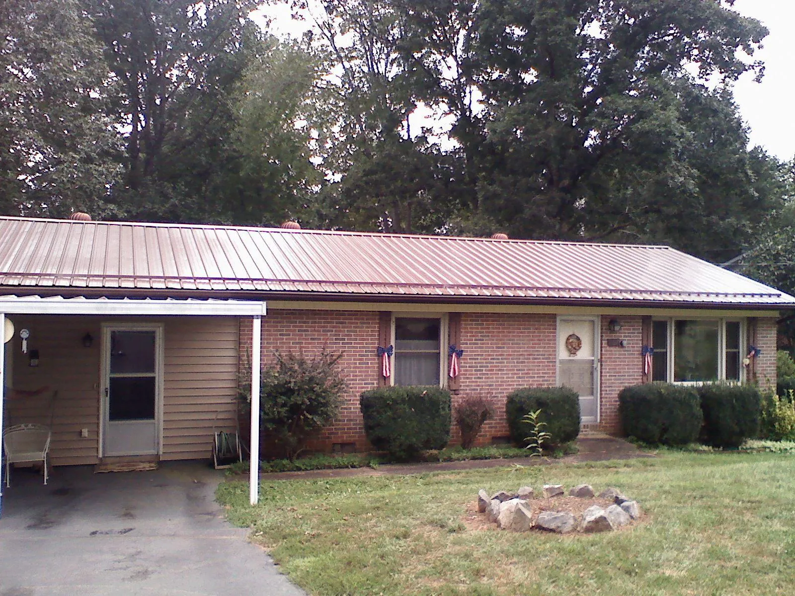 Bronze metal roof and carport on a brick ranch home — Roof Repair work by our crew in Glenville